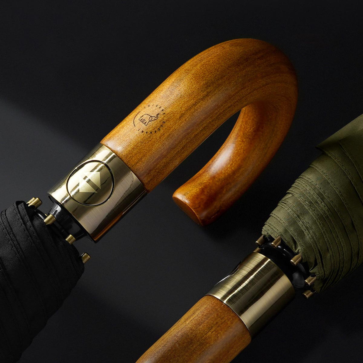 Close-up of handcrafted wooden handle on storm proof folding umbrella with luxury metal hardware