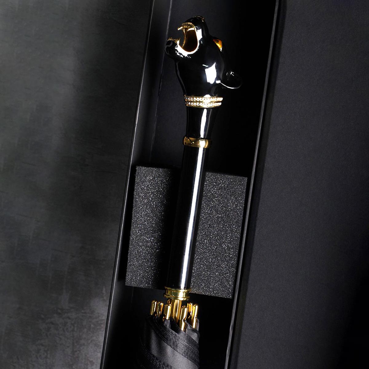 Close-up of Elegant Black Umbrella's gold-accented luxury handle