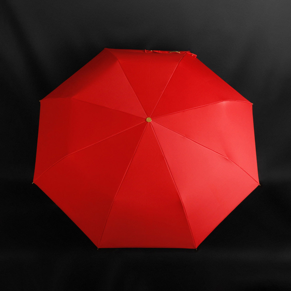 Compact parasol with a fashionable twist - red canopy and scorpion handle